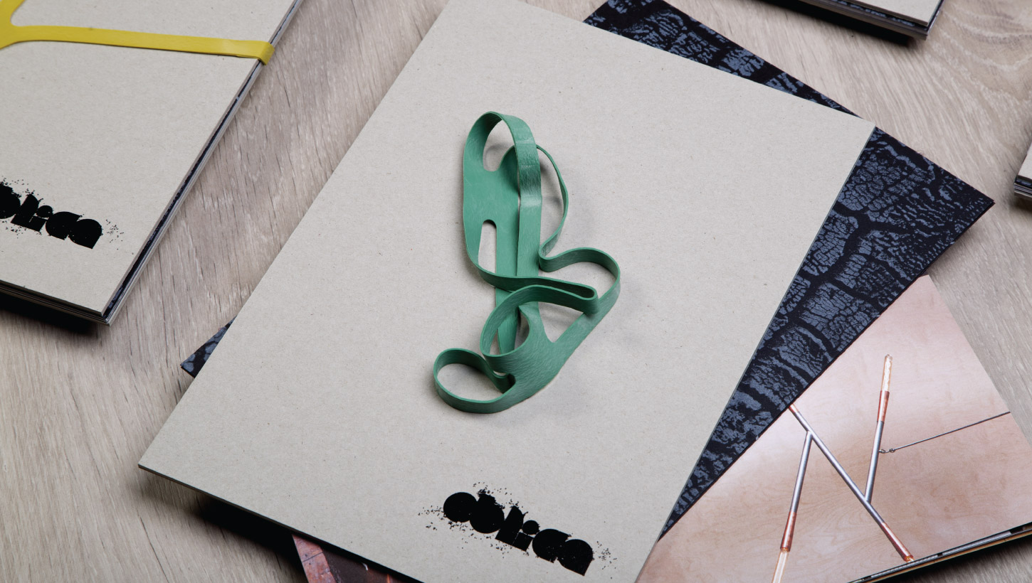Oblica brochure with green rubber band