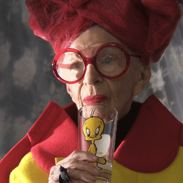 Iris Apfel sipping from tweety glass