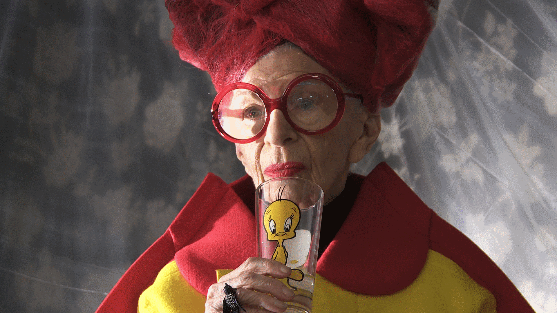 Iris Apfel sipping from tweety glass